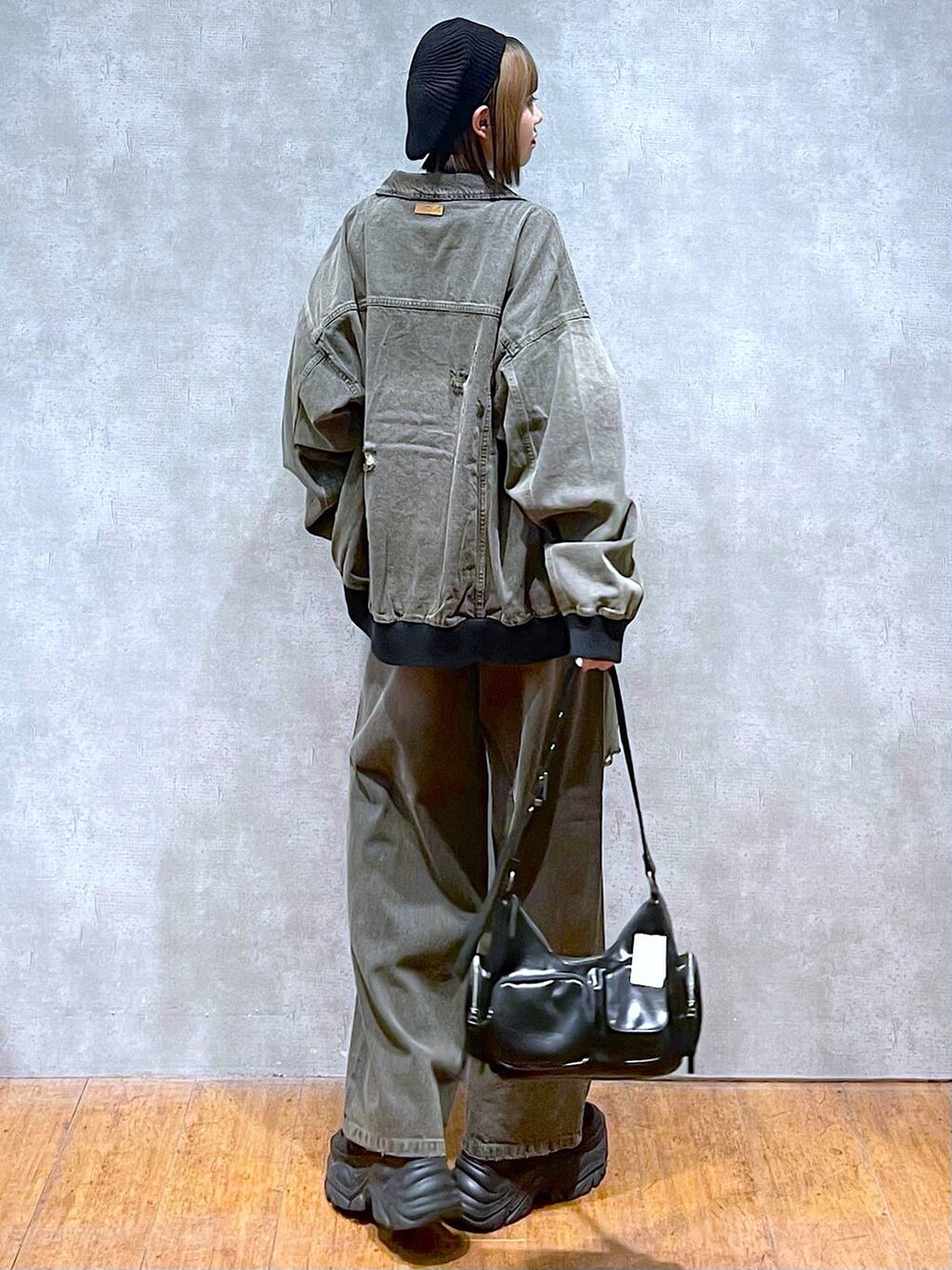 ブラック系のスニーカー、ブラック系のTシャツ/カットソー、ブラック系のブルゾンを着用したレディースの秋コーディネートの5枚目の写真