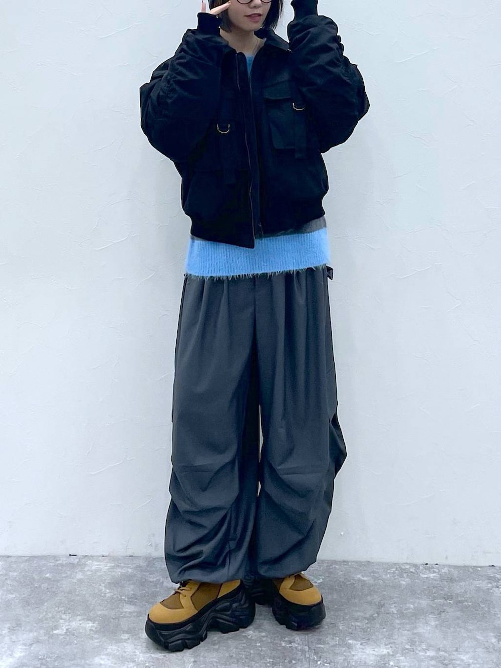 ブラウン系のブーツ、ブラック系のブルゾン、グレー系のカーゴパンツを着用したレディースの秋コーディネートの6枚目の写真