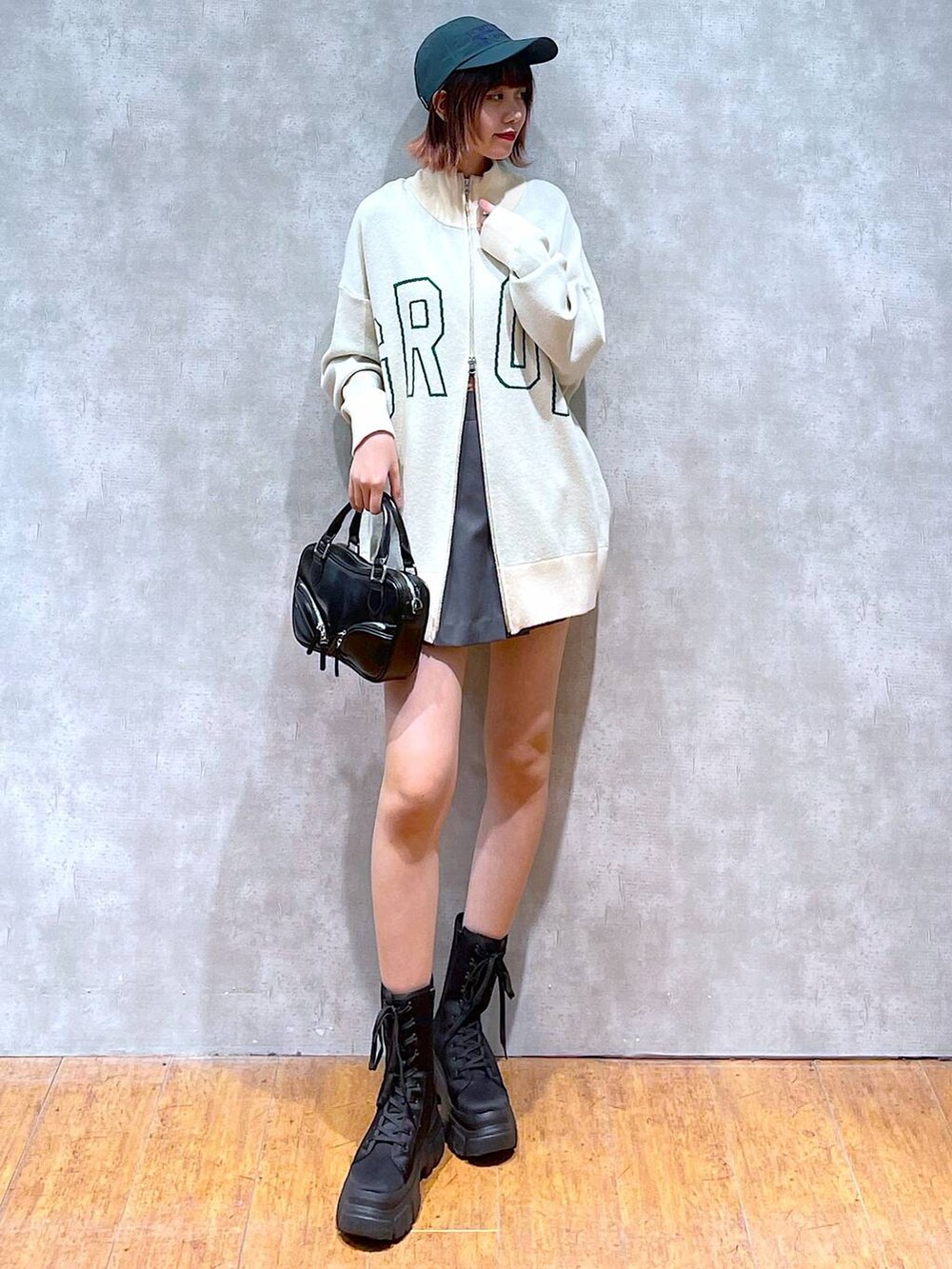 ベージュ系のニット/セーター、グレー系のその他パンツ、ブラック系のブーツを着用したレディースの春コーディネートの5枚目の写真