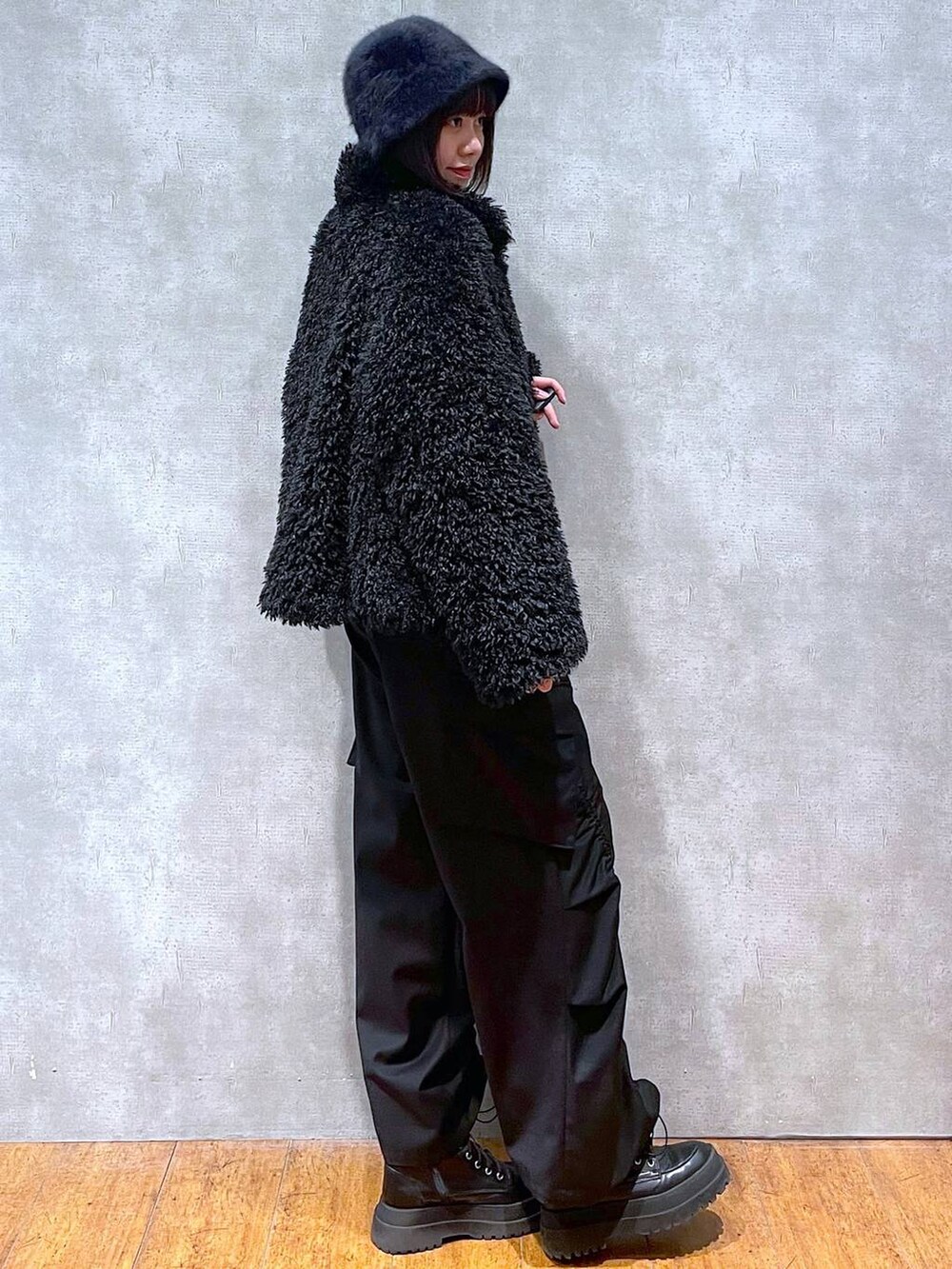 ブラック系のブーツ、ベージュ系のニット/セーター、ブラック系のその他アウターを着用したレディースの冬コーディネートの2枚目の写真