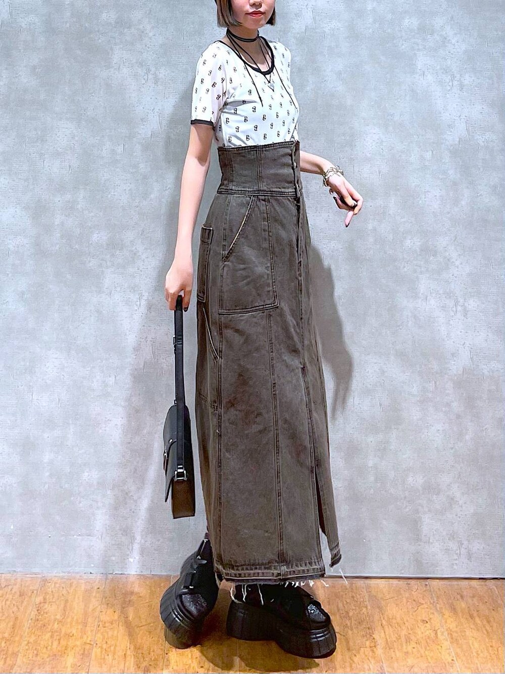 ブラック系のスニーカー、ブラック系のデニムスカート、ブラック系のハンドバッグを着用したレディースの夏コーディネートの4枚目の写真