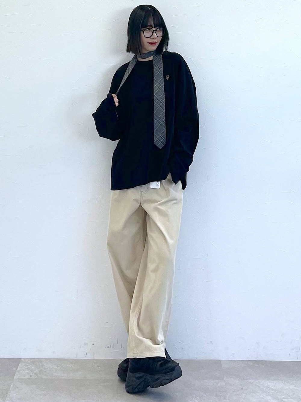 ブラック系のスニーカー、グレー系のネクタイ、ブラック系のTシャツ/カットソーを着用したレディースの秋コーディネートの2枚目の写真