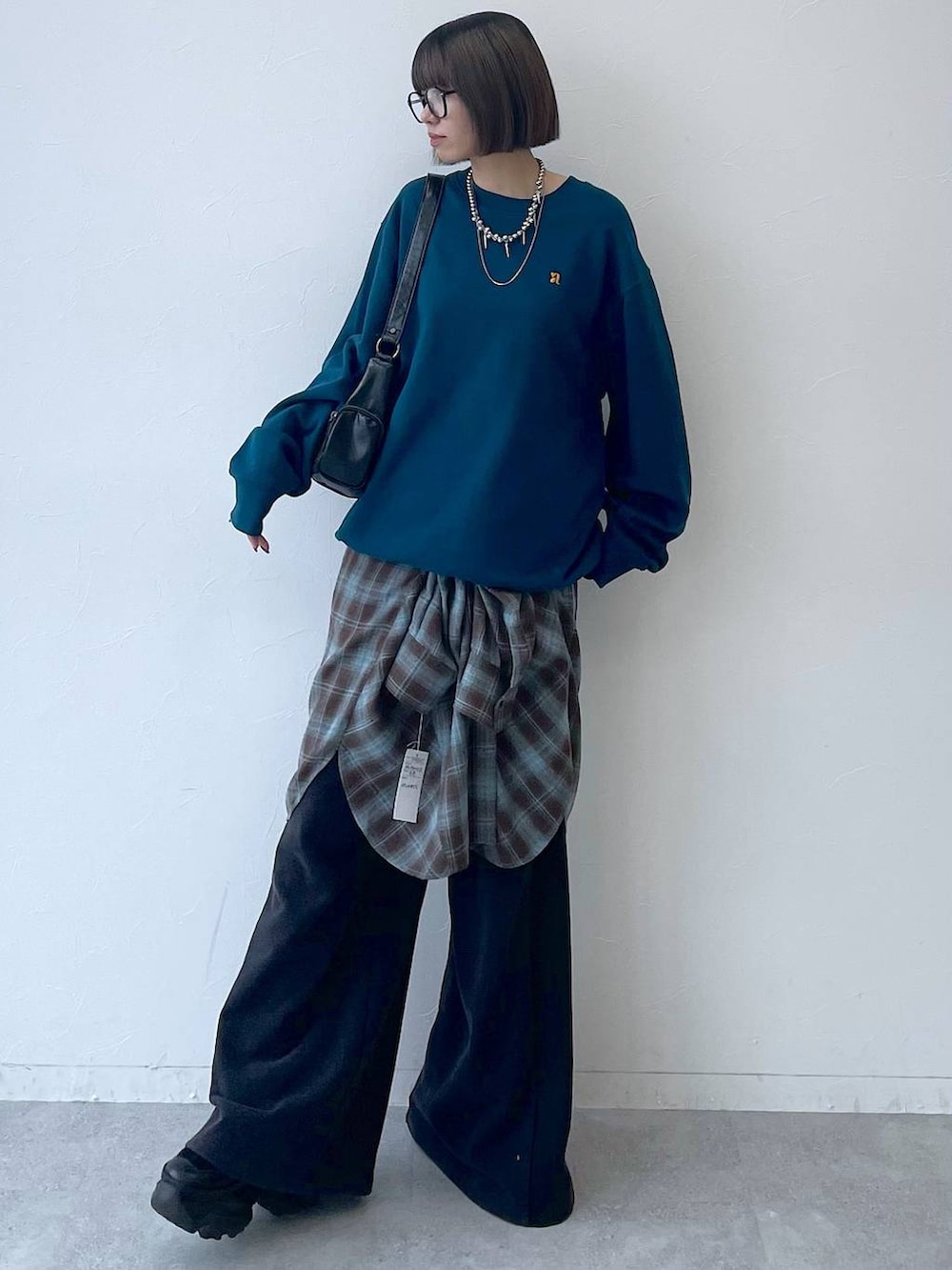 ブラック系のスニーカー、ブラック系のショルダーバッグ、グリーン系のスウェットを着用したレディースの秋コーディネートの2枚目の写真