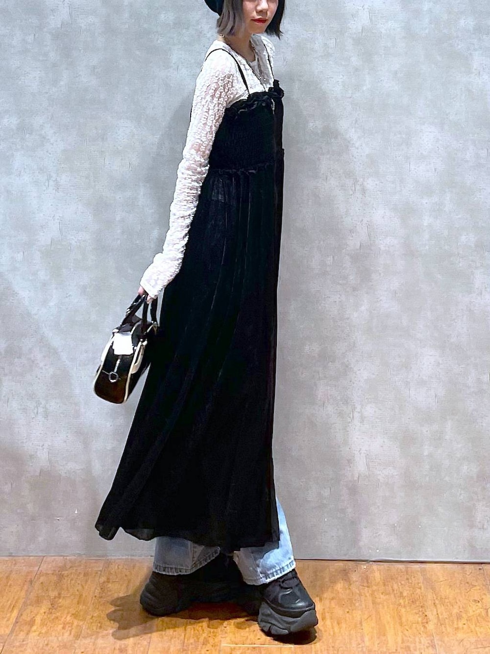 ブラック系のスニーカー、ブラック系のショルダーバッグ、ブルー系のデニムパンツを着用したレディースの夏コーディネートの5枚目の写真