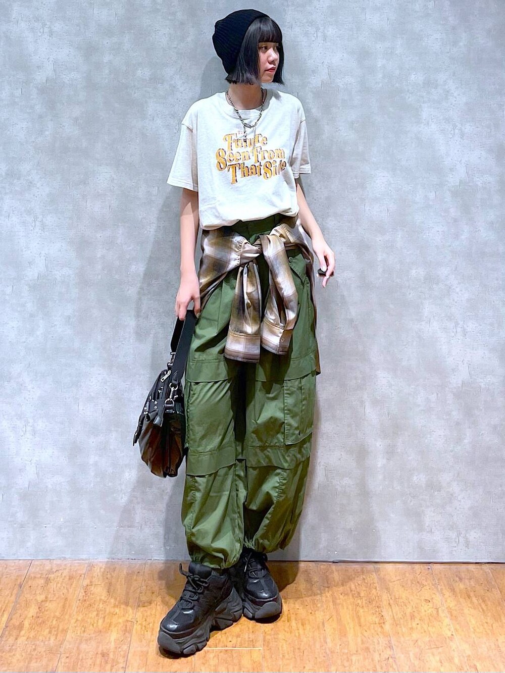 ブラック系のスニーカー、グリーン系のその他パンツ、ベージュ系のTシャツ/カットソーを着用したレディースの夏コーディネートの6枚目の写真