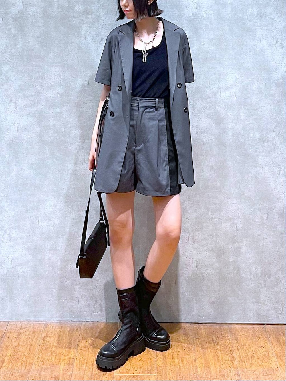 ブラック系のハンドバッグ、グレー系のテーラードジャケット、グレー系のその他パンツを着用したレディースの夏コーディネートの2枚目の写真