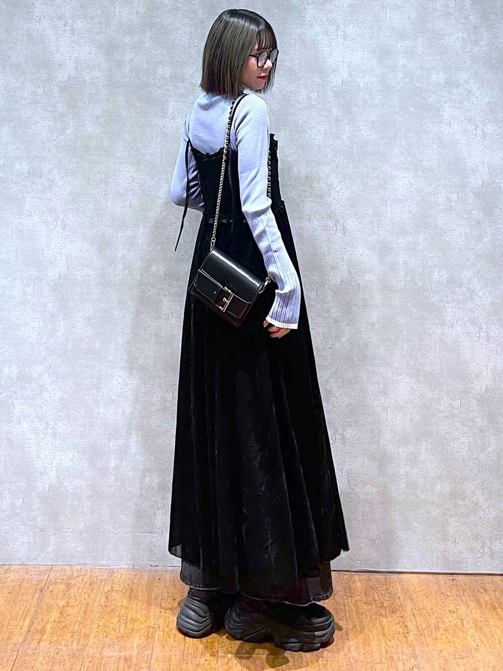 ブラック系のスニーカー、ブルー系のニット/セーター、ブラック系のデニムパンツを着用したレディースの秋コーディネートの5枚目の写真