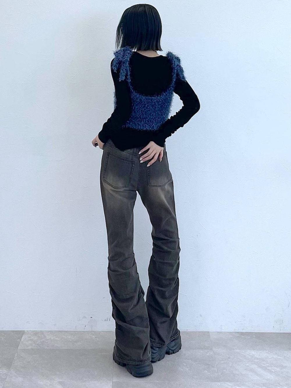 ブラック系のスニーカー、ブラック系のデニムパンツ、ブルー系のTシャツ/カットソーを着用したレディースの秋コーディネートの2枚目の写真