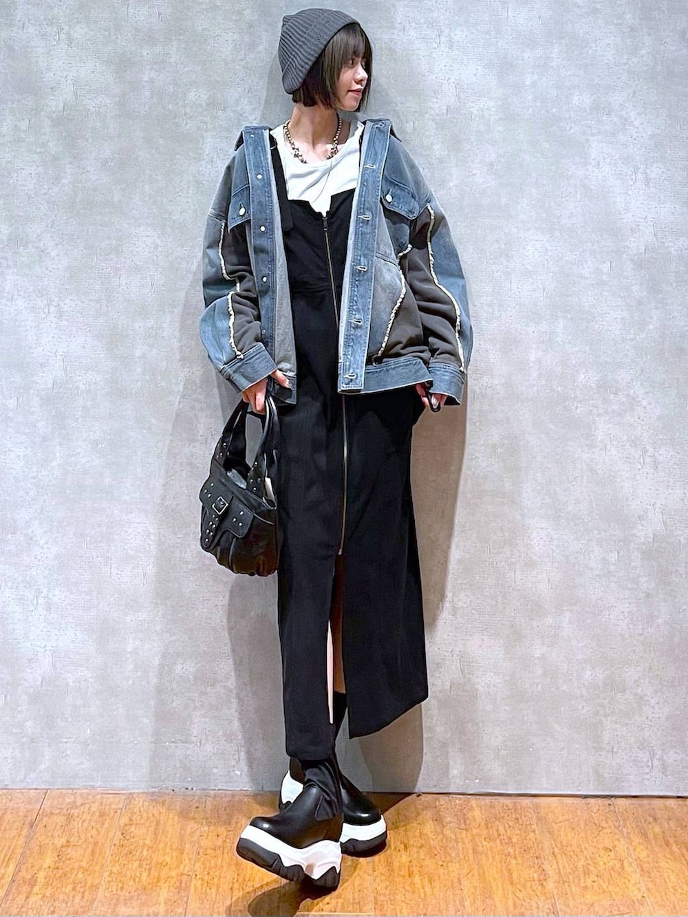 ブルー系のブルゾン、ブラック系のハンドバッグ、ホワイト系のTシャツ/カットソーを着用したレディースの秋コーディネートの6枚目の写真