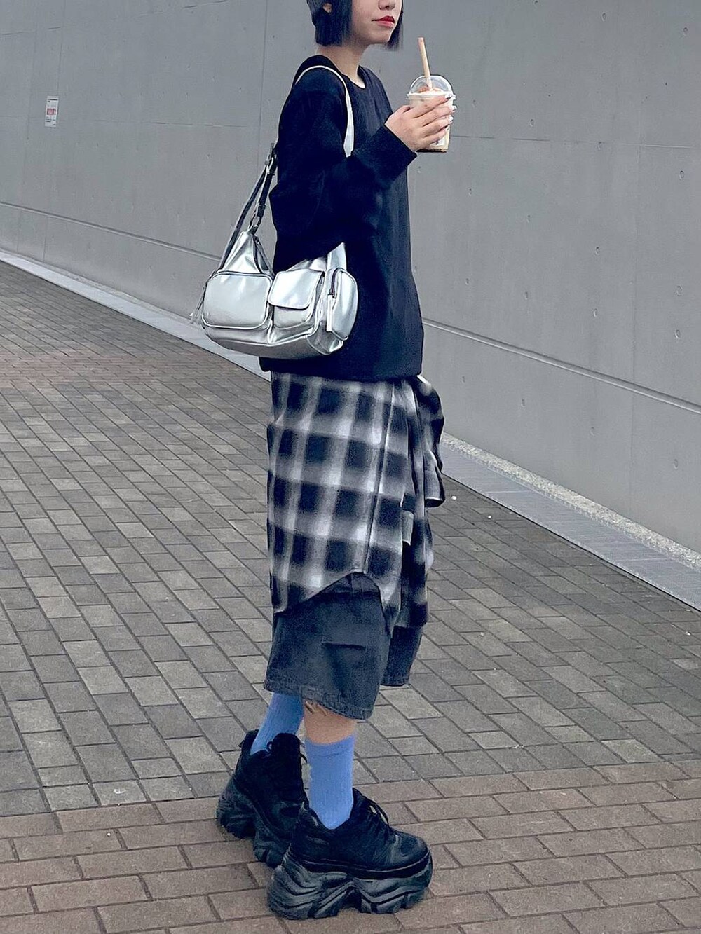 ブラック系のスニーカー、ブラック系のシャツ/ブラウス、ブラック系のデニムパンツを着用したレディースの秋コーディネートの7枚目の写真