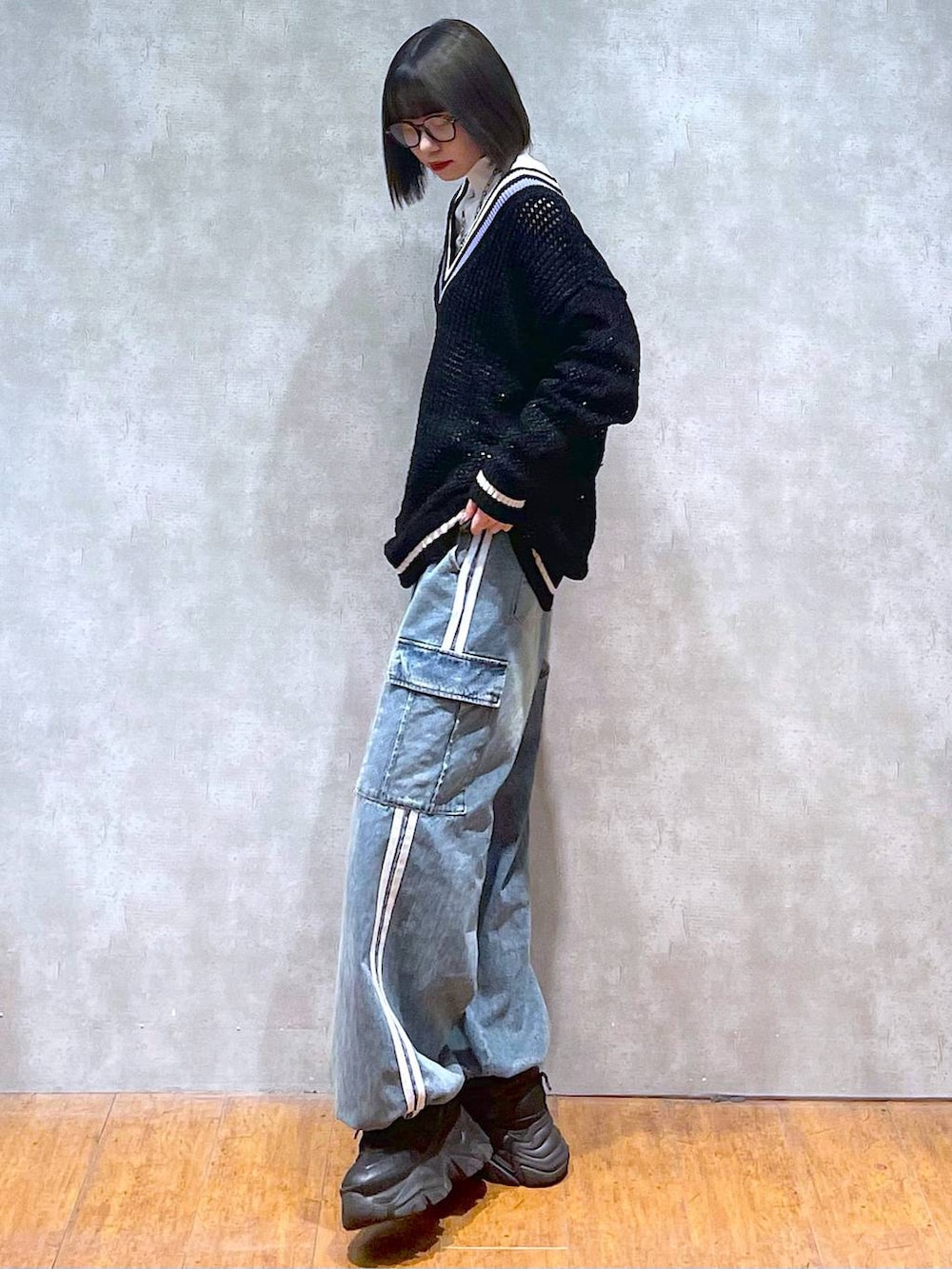 ブラック系のスニーカー、ブルー系のデニムパンツ、ブラック系のニット/セーターを着用したレディースの秋コーディネートの3枚目の写真