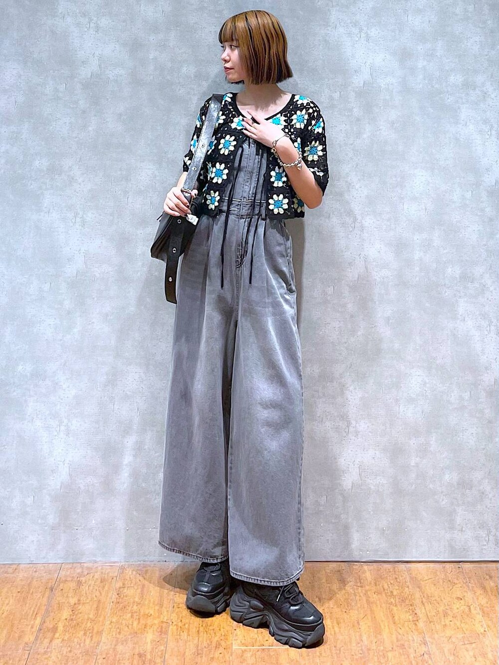 ブラック系のスニーカー、ブラック系のサロペット/オーバーオール、ブラック系のニット/セーターを着用したレディースの夏コーディネートの7枚目の写真