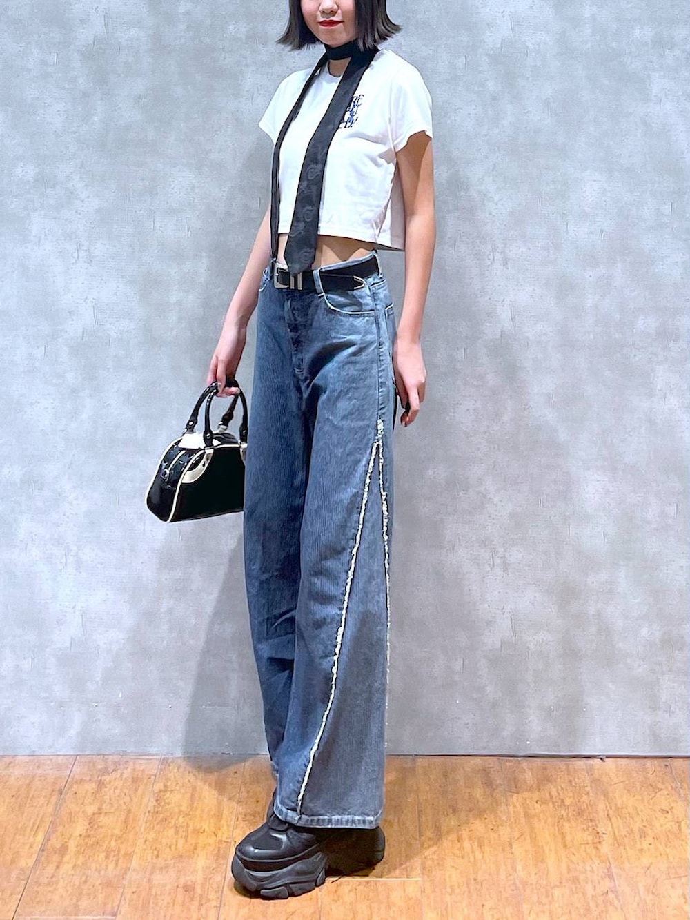 ブラック系のスニーカー、ホワイト系のTシャツ/カットソー、ブラック系のネクタイを着用したレディースの夏コーディネートの4枚目の写真