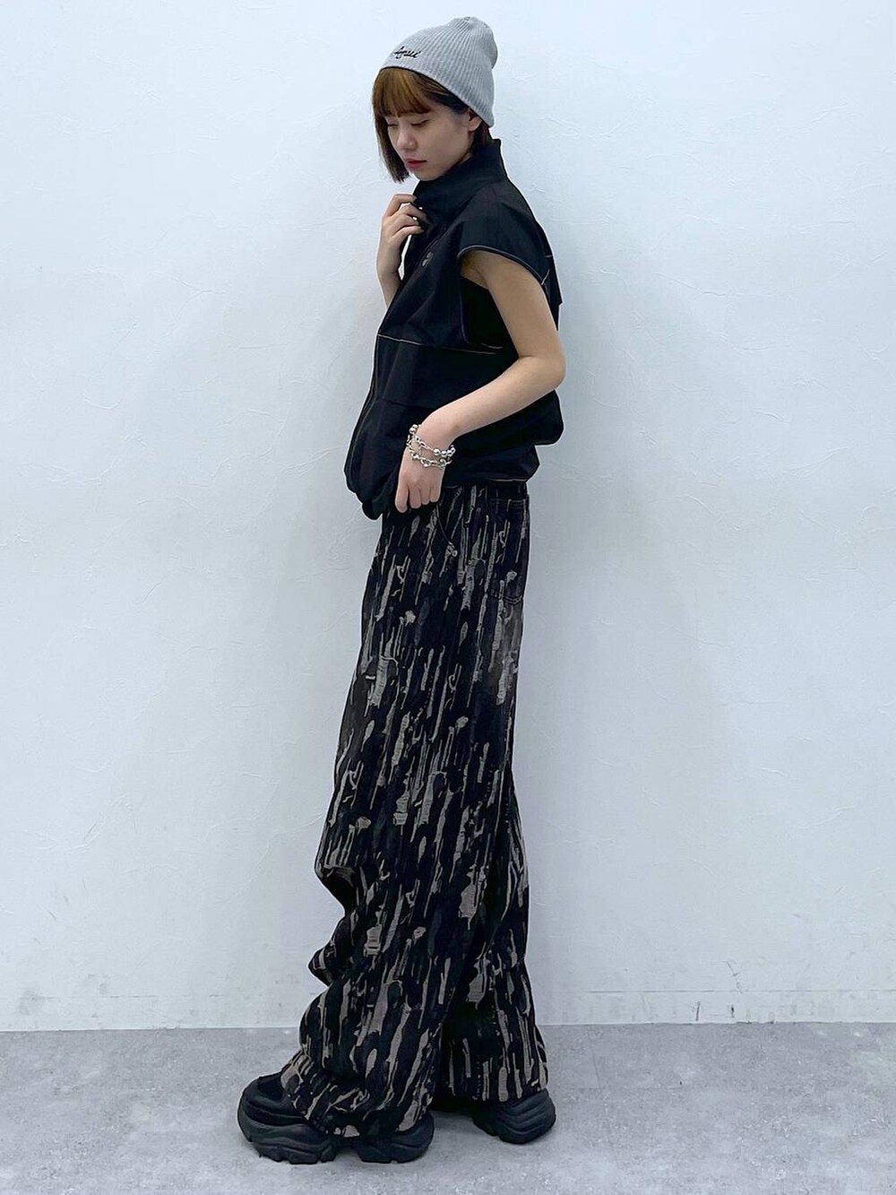 ブラック系のスニーカー、ブラック系のベスト、ブラック系のデニムパンツを着用したレディースの夏コーディネートの2枚目の写真