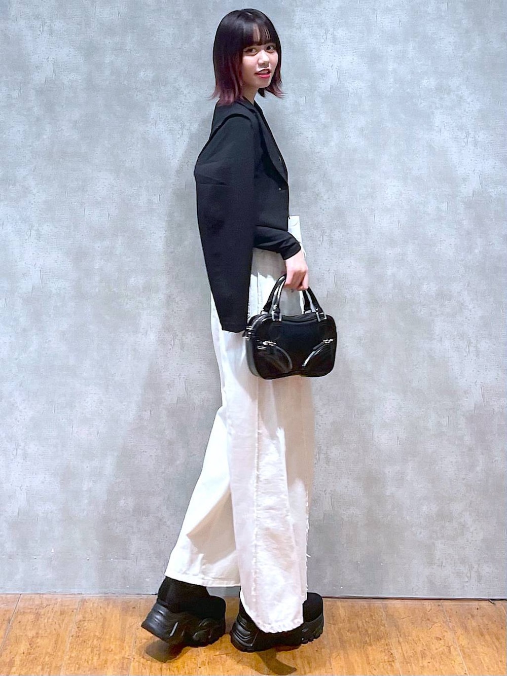 ホワイト系のTシャツ/カットソー、ブラック系のテーラードジャケット、ブラック系のボストンバッグを着用したレディースの春コーディネートの3枚目の写真