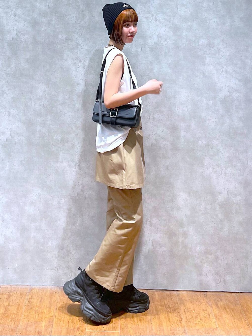 ブラック系のスニーカー、ブラック系のハンドバッグ、ホワイト系のTシャツ/カットソーを着用したレディースの夏コーディネートの4枚目の写真