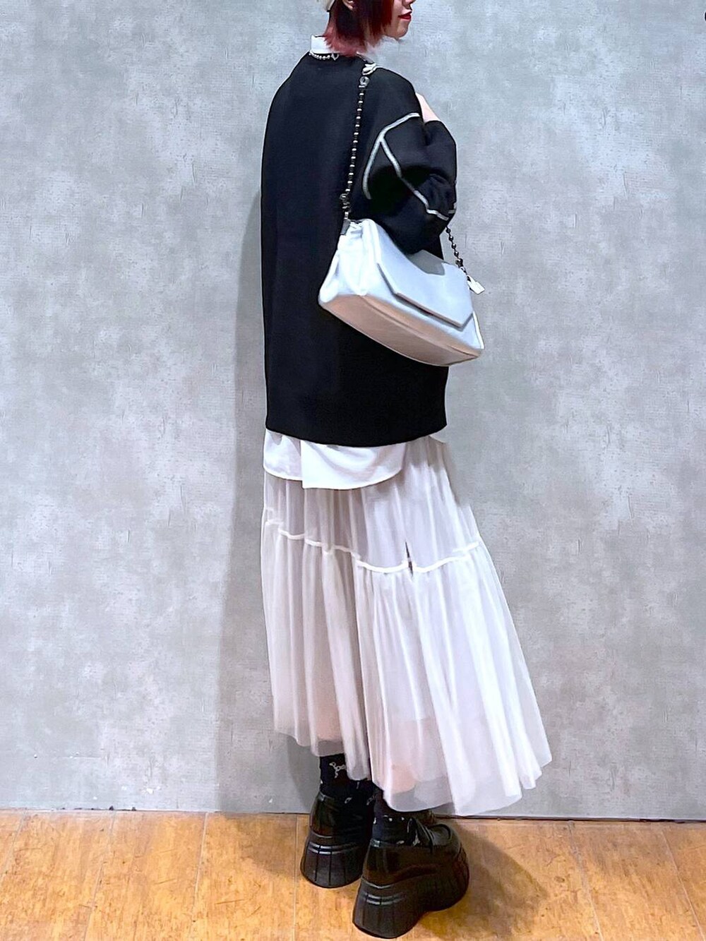 シルバー系のショルダーバッグ、ホワイト系のシャツ/ブラウス、ブラック系のニット/セーターを着用したレディースの春コーディネートの3枚目の写真