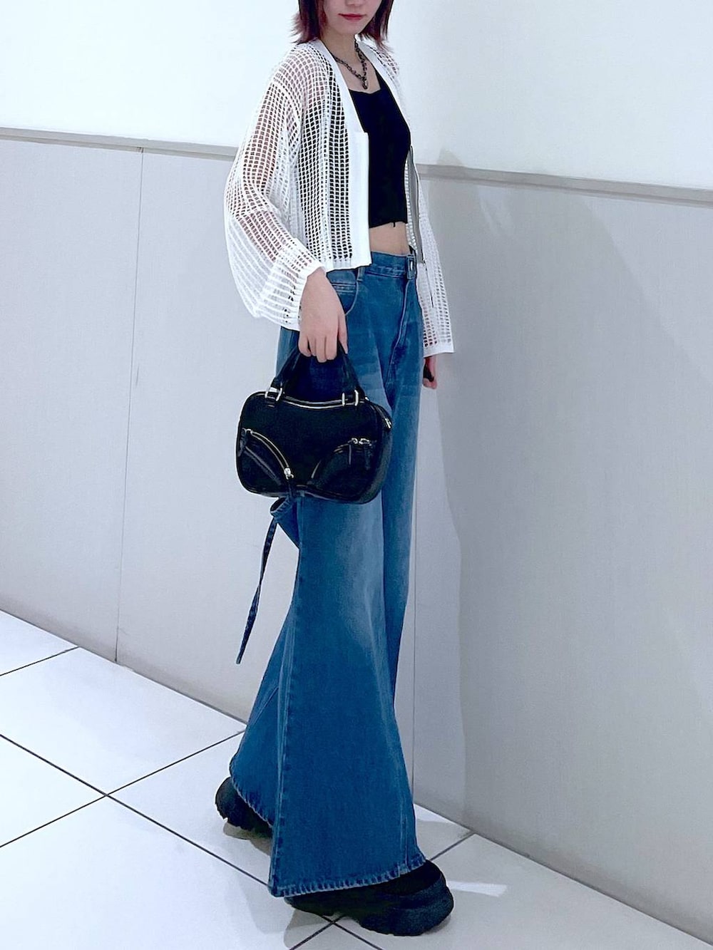 ホワイト系のカーディガン/ボレロ、ブラック系のタンクトップ、ブルー系のデニムパンツを着用したレディースの春コーディネートの4枚目の写真