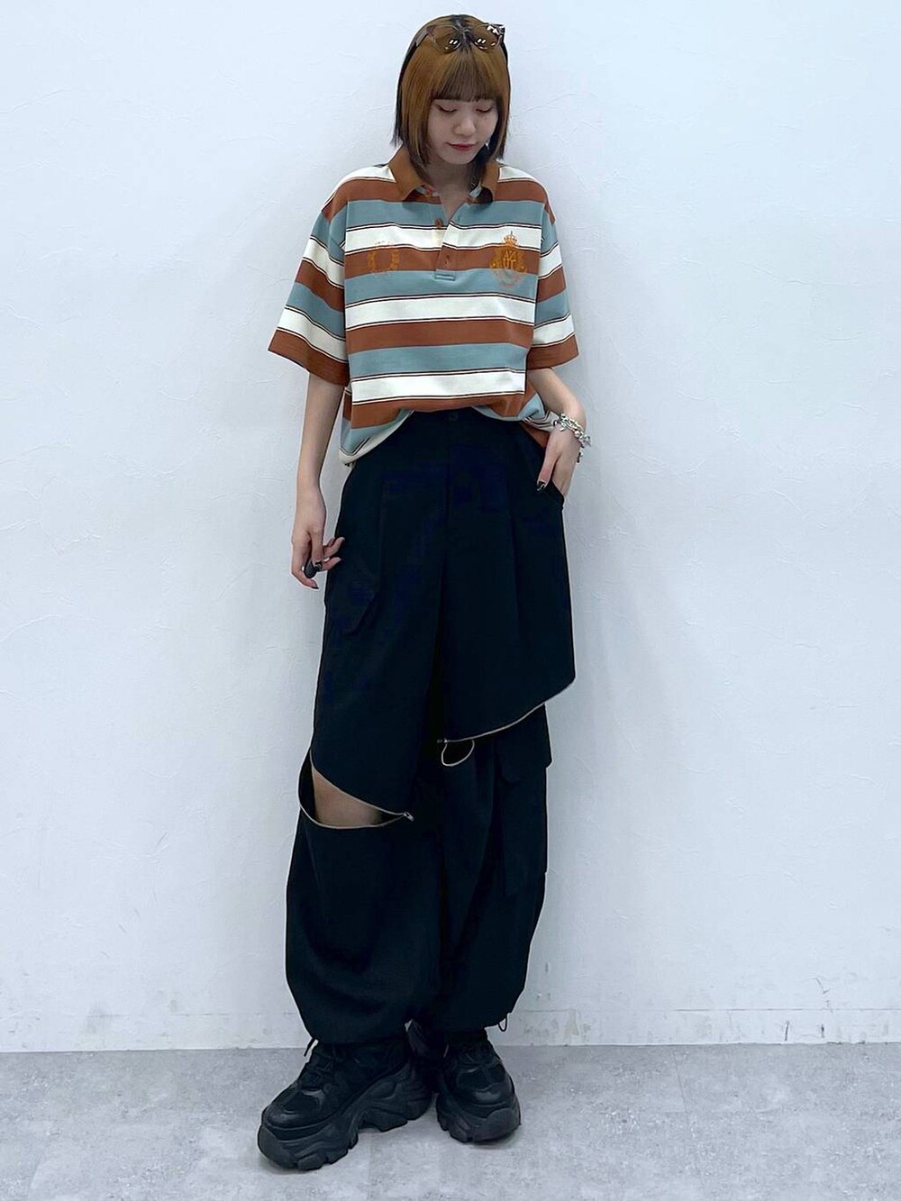 ブラック系のスニーカー、ブラック系のカーゴパンツ、ブラウン系のTシャツ/カットソーを着用したレディースの夏コーディネートの2枚目の写真