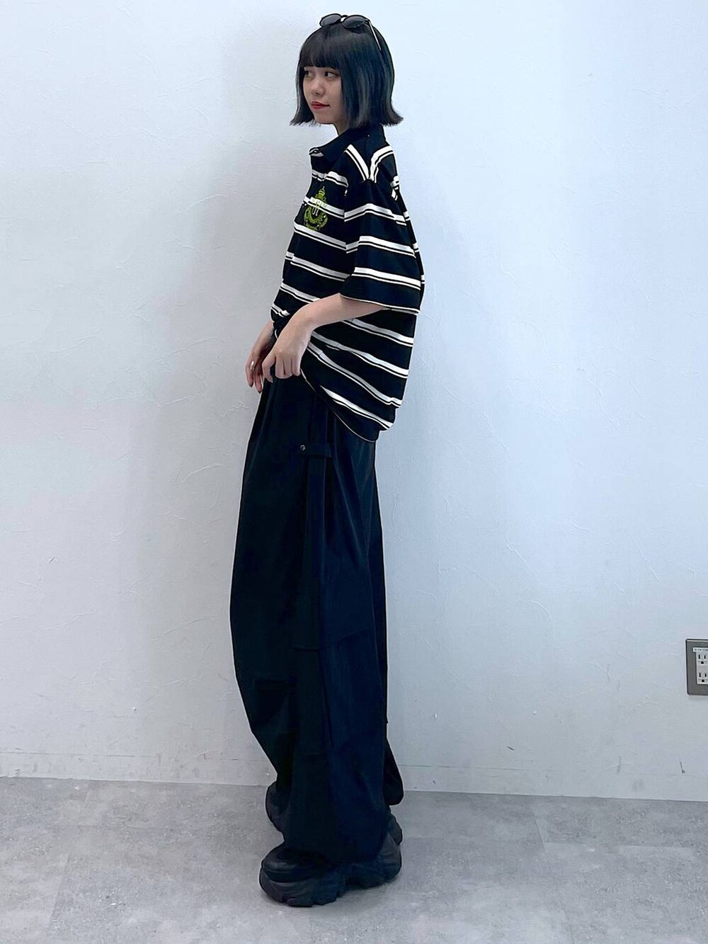 ブラック系のスニーカー、ブラック系のカーゴパンツ、ブラック系のTシャツ/カットソーを着用したレディースの夏コーディネートの3枚目の写真