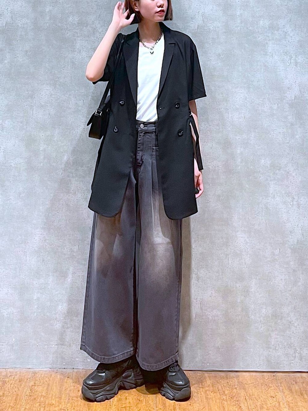 ブラック系のスニーカー、ホワイト系のTシャツ/カットソー、ブラック系のハンドバッグを着用したレディースの夏コーディネートの7枚目の写真