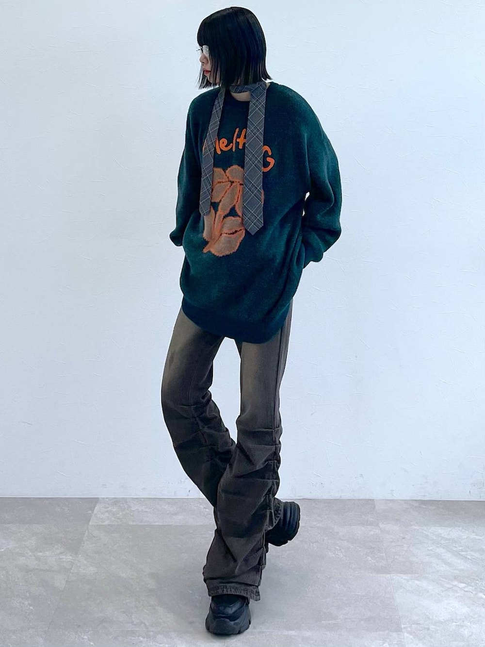 ブラック系のスニーカー、グレー系のネクタイ、ブラック系のデニムパンツを着用したレディースの秋コーディネートの2枚目の写真