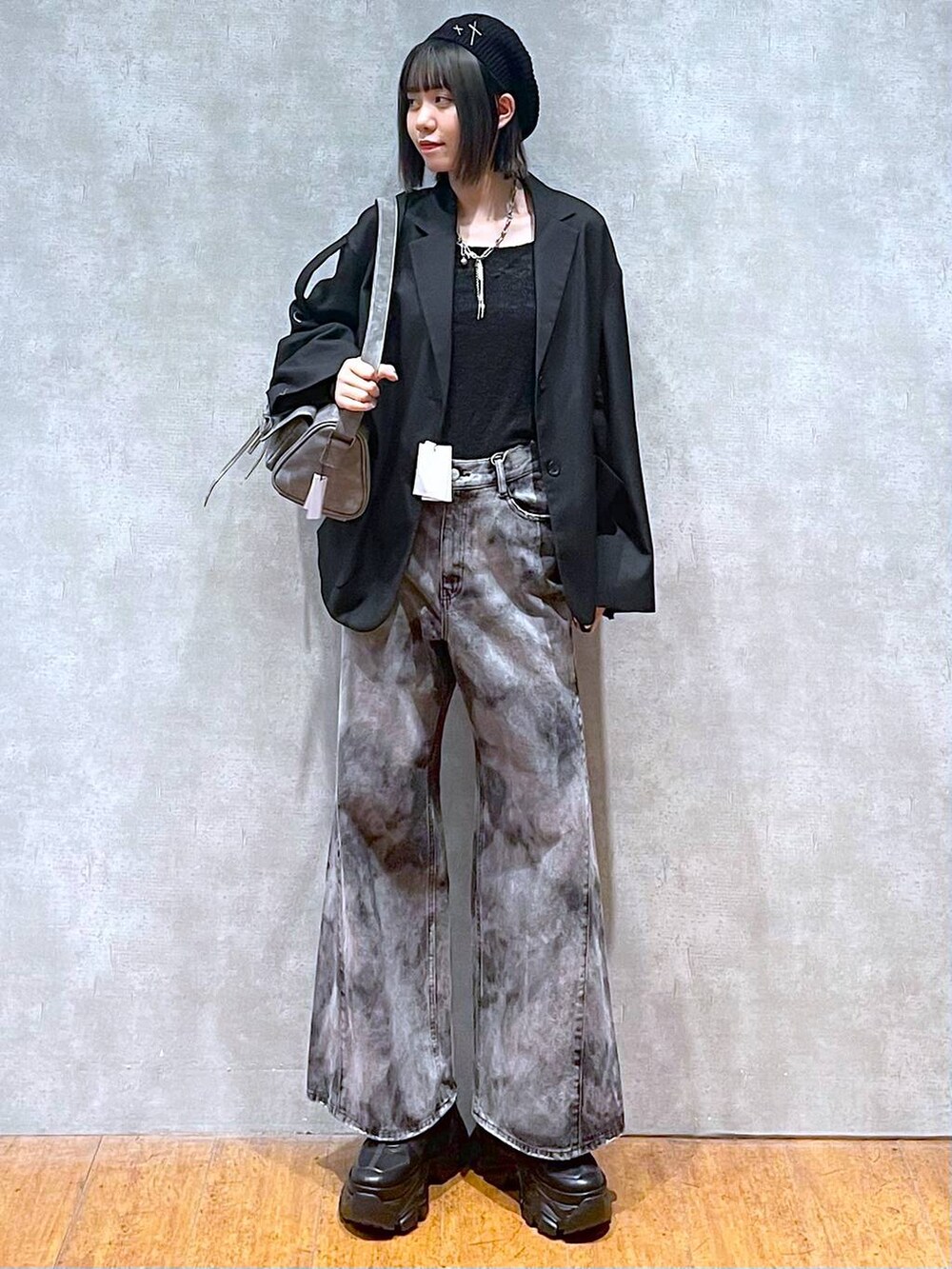 ブラック系のスニーカー、グレー系のショルダーバッグ、ブラック系のデニムパンツを着用したレディースの秋コーディネートの8枚目の写真