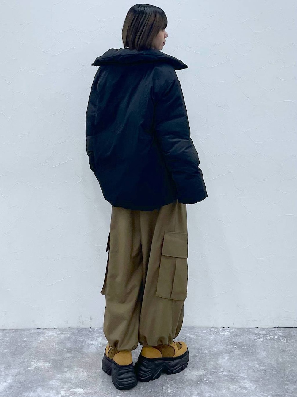 ブラウン系のブーツ、ベージュ系のカーゴパンツ、ブラック系のブルゾンを着用したレディースの秋コーディネートの4枚目の写真