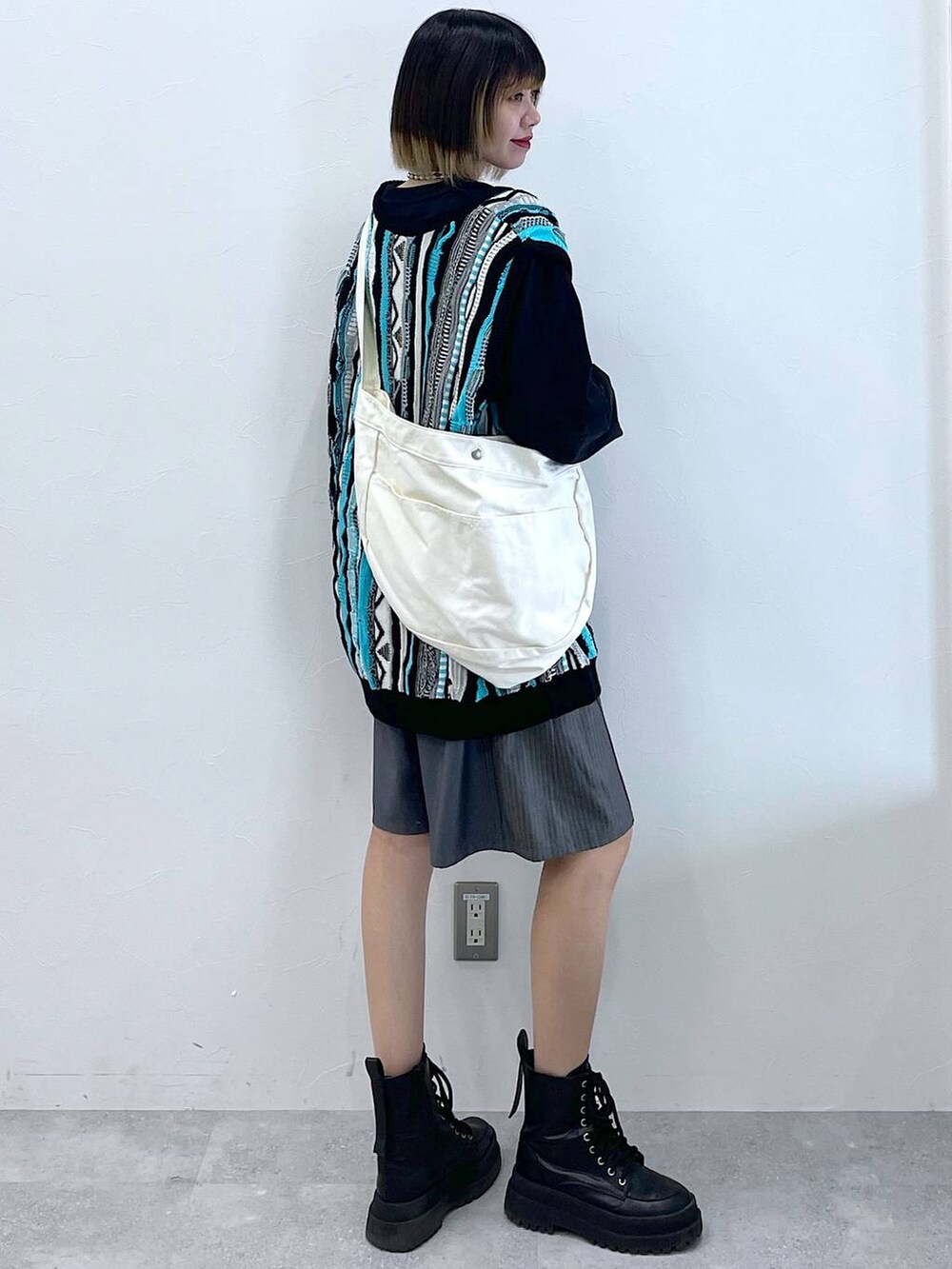 グレー系のスラックス、ブラック系のTシャツ/カットソー、ブラック系のブーツを着用したレディースの春コーディネートの6枚目の写真