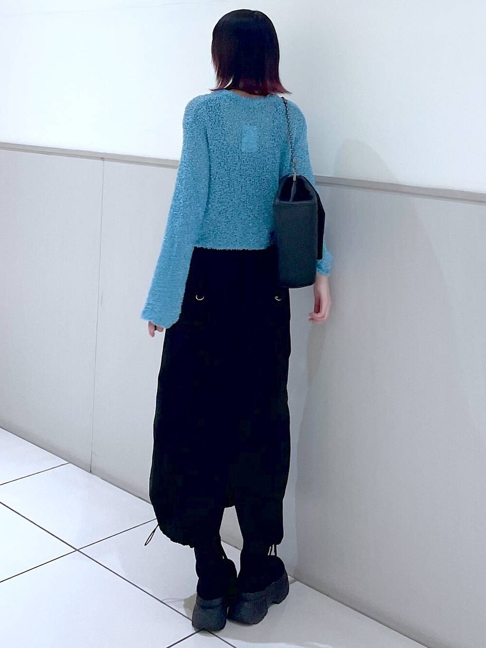 ブラック系のショルダーバッグ、ブラック系のタンクトップ、ブラック系のブーツを着用したレディースの春コーディネートの4枚目の写真