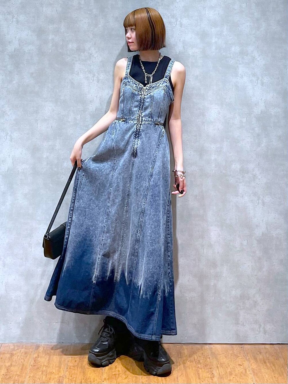 ブラック系のスニーカー、ブルー系のワンピース、ブラック系のハンドバッグを着用したレディースの夏コーディネートの5枚目の写真