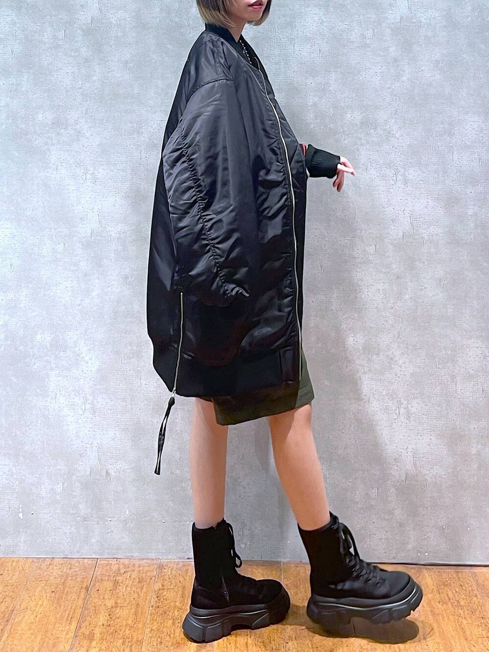 グリーン系のカーゴパンツ、ブラック系のMA-1、ブラック系のニット/セーターを着用したレディースの冬コーディネートの5枚目の写真