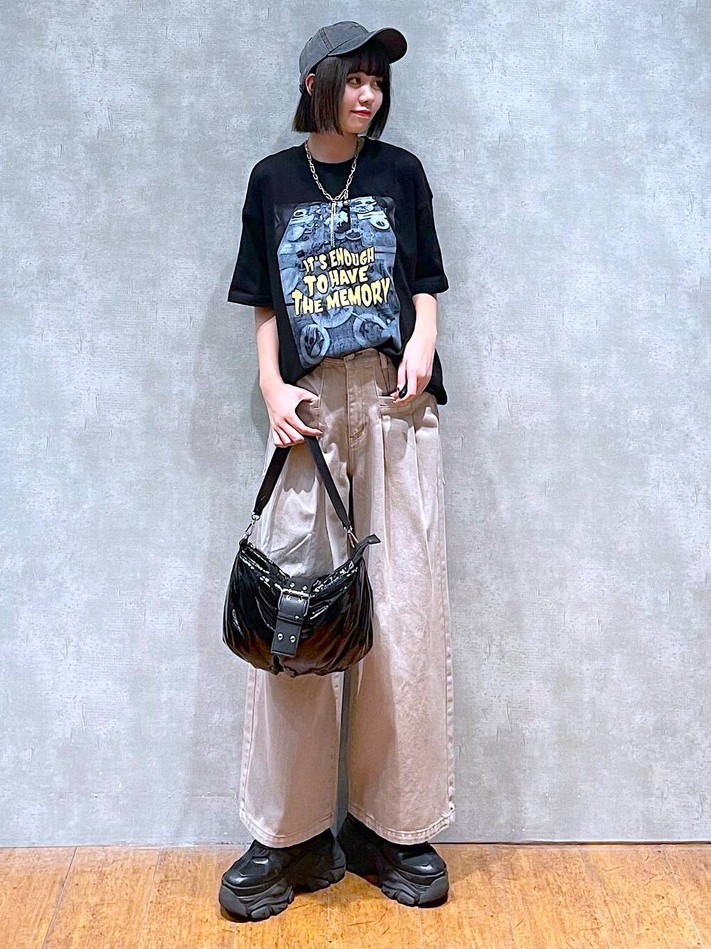 ブラック系のスニーカー、ブラック系のショルダーバッグ、ベージュ系のデニムパンツを着用したレディースの夏コーディネートの9枚目の写真