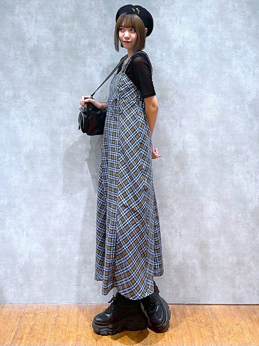 ブラック系のスニーカー、ブラック系のショルダーバッグ、ブルー系のワンピースを着用したレディースの秋コーディネートの2枚目の写真