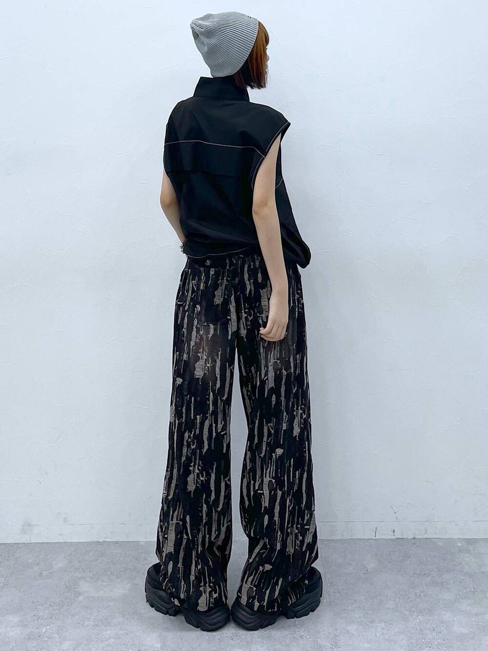 ブラック系のスニーカー、ブラック系のベスト、ブラック系のデニムパンツを着用したレディースの夏コーディネートの7枚目の写真