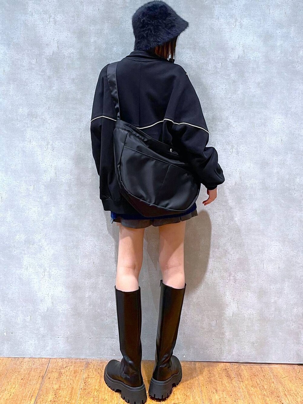 ブラック系のブーツ、ブラック系のスウェット、グレー系のその他パンツを着用したレディースの冬コーディネートの3枚目の写真