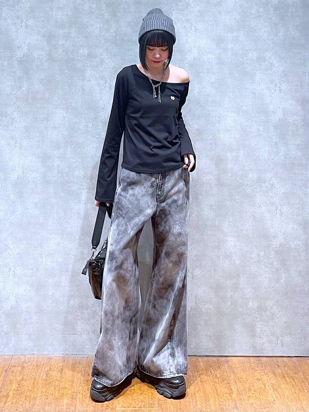 ブラック系のスニーカー、ブラック系のショルダーバッグ、ブラック系のデニムパンツを着用したレディースの夏コーディネートの2枚目の写真