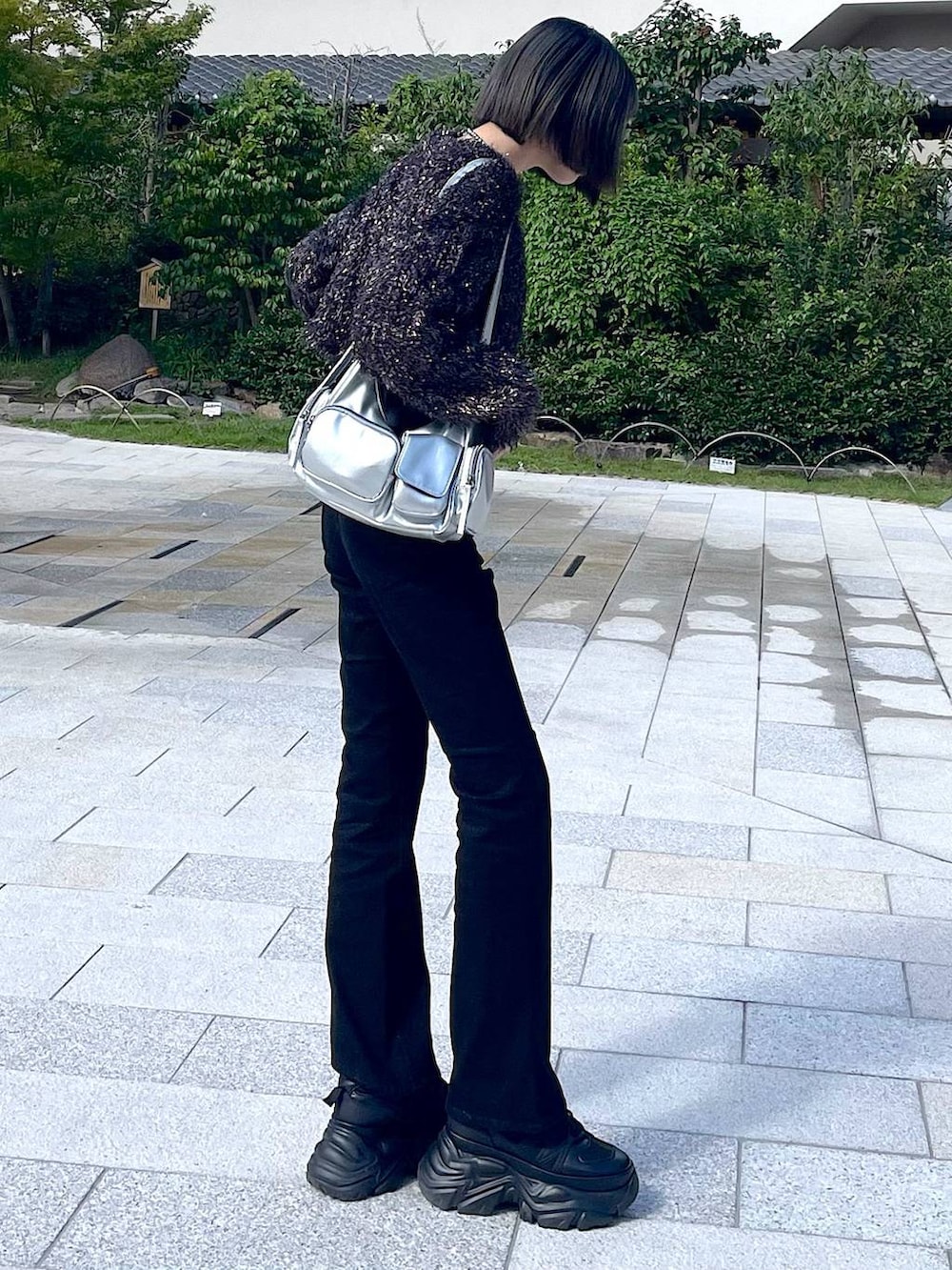 ブラック系のスニーカー、シルバー系のショルダーバッグ、ブラック系のニット/セーターを着用したレディースの秋コーディネートの5枚目の写真