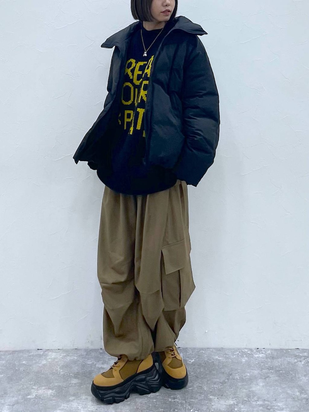 ブラウン系のブーツ、ベージュ系のカーゴパンツ、ブラック系のブルゾンを着用したレディースの秋コーディネートの3枚目の写真