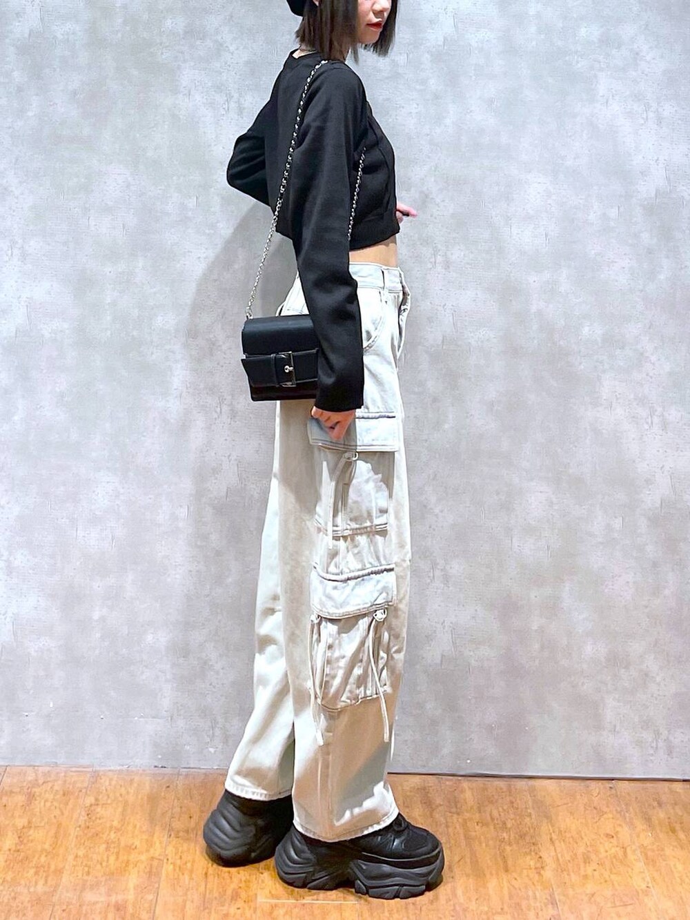 ブラック系のスニーカー、ブルー系のデニムパンツ、ブラック系のショルダーバッグを着用したレディースの秋コーディネートの6枚目の写真