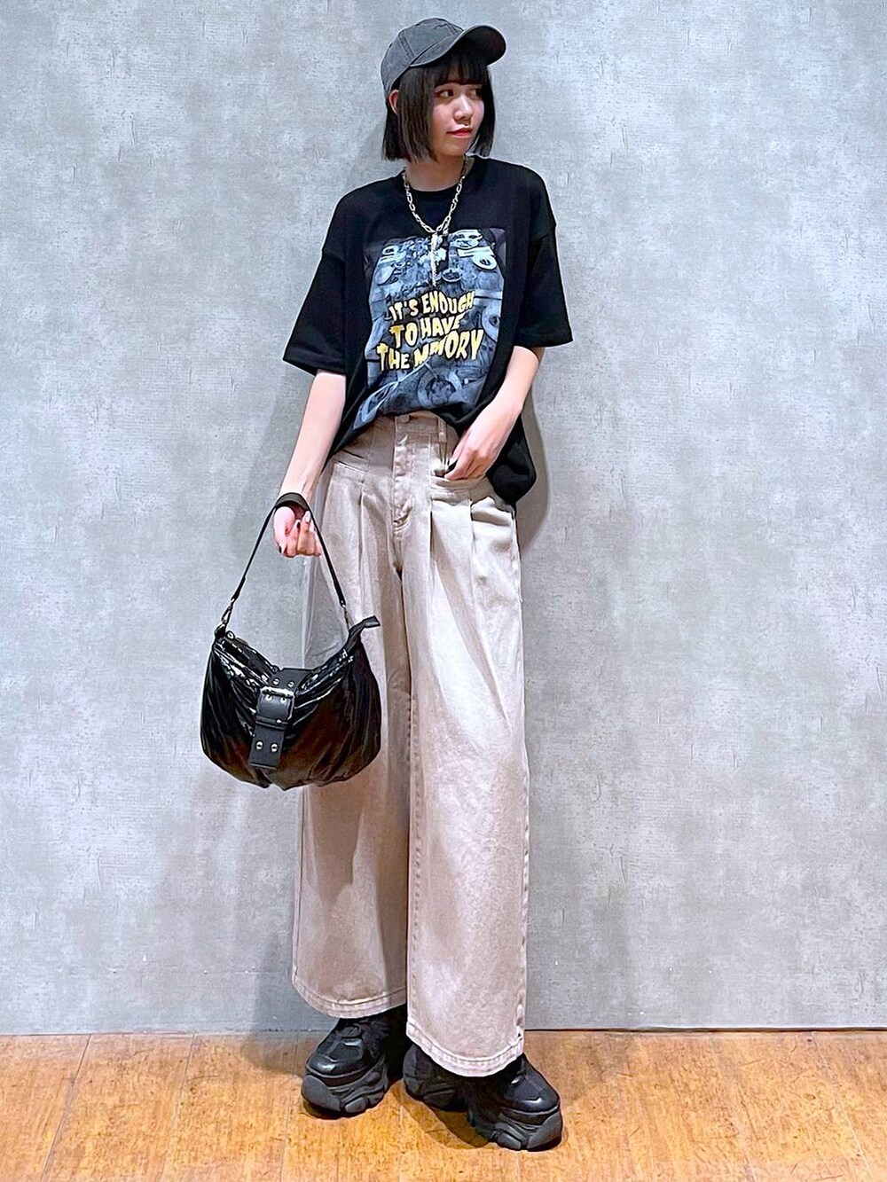 ブラック系のスニーカー、ブラック系のショルダーバッグ、ベージュ系のデニムパンツを着用したレディースの夏コーディネートの3枚目の写真