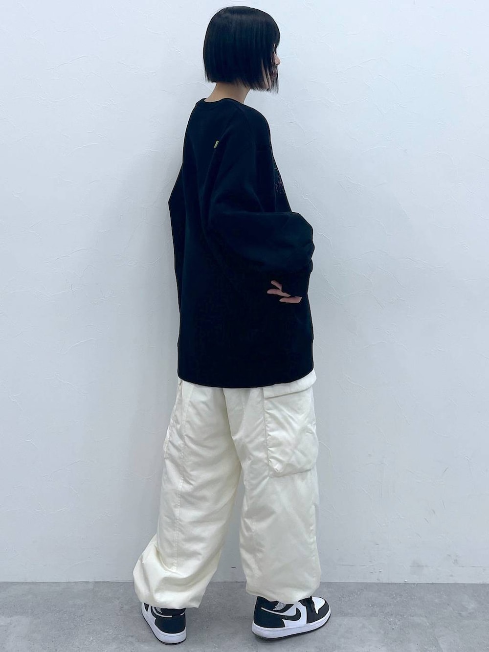 ホワイト系のカーゴパンツ、ブラック系のスウェットを着用したレディースの冬コーディネートの4枚目の写真