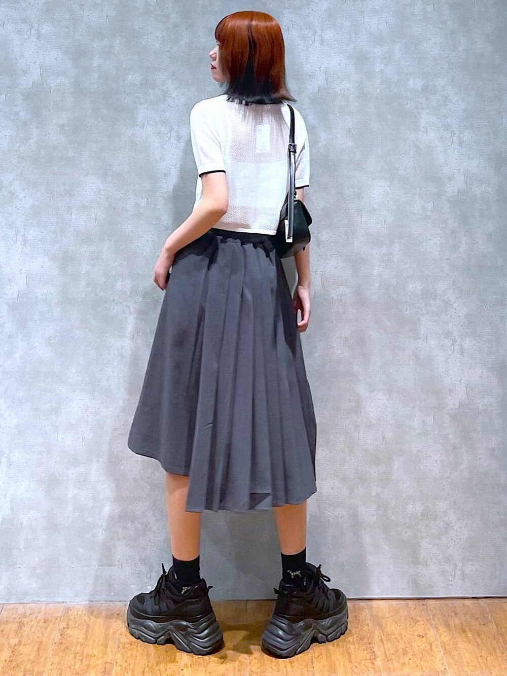 ブラック系のスニーカー、グレー系のスカート、ホワイト系のキャミソールを着用したレディースの夏コーディネートの6枚目の写真