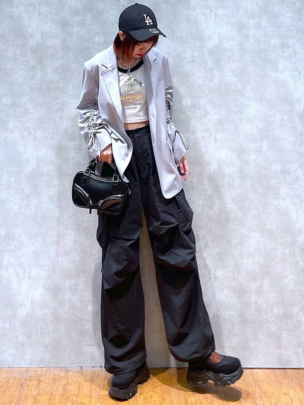 ベージュ系のテーラードジャケット、ホワイト系のTシャツ/カットソー、ブラック系のカーゴパンツを着用したレディースの春コーディネートの3枚目の写真