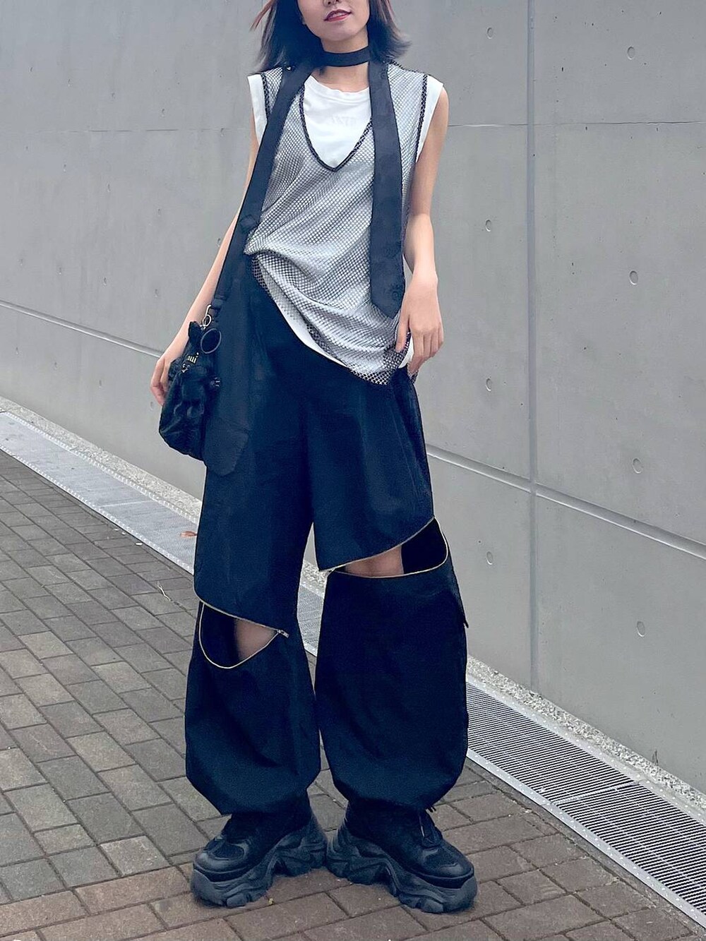 ブラック系のショルダーバッグ、ブラック系のスニーカー、ブラック系のネクタイを着用したレディースの春コーディネートの7枚目の写真