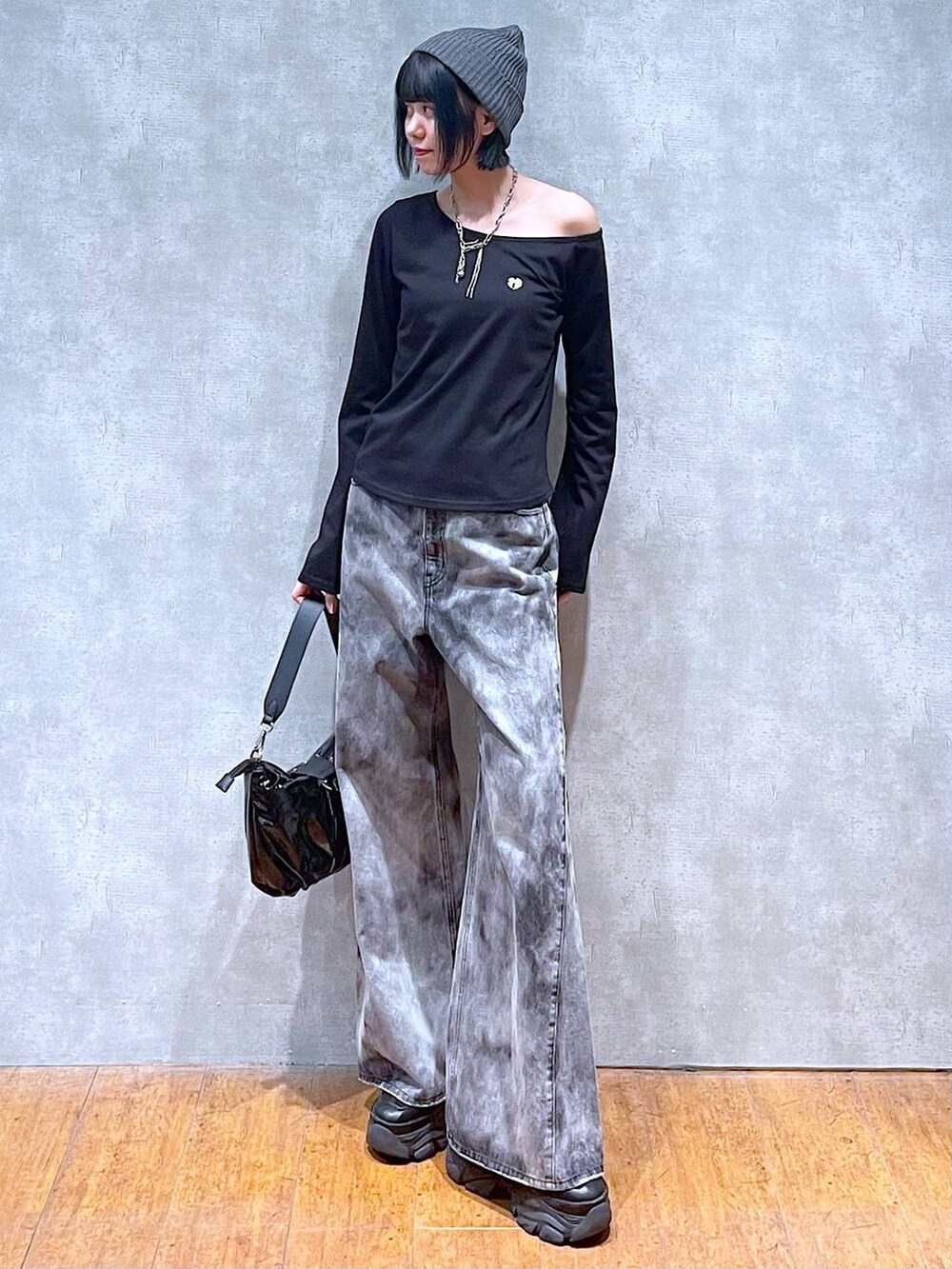 ブラック系のスニーカー、ブラック系のショルダーバッグ、ブラック系のデニムパンツを着用したレディースの夏コーディネートの3枚目の写真