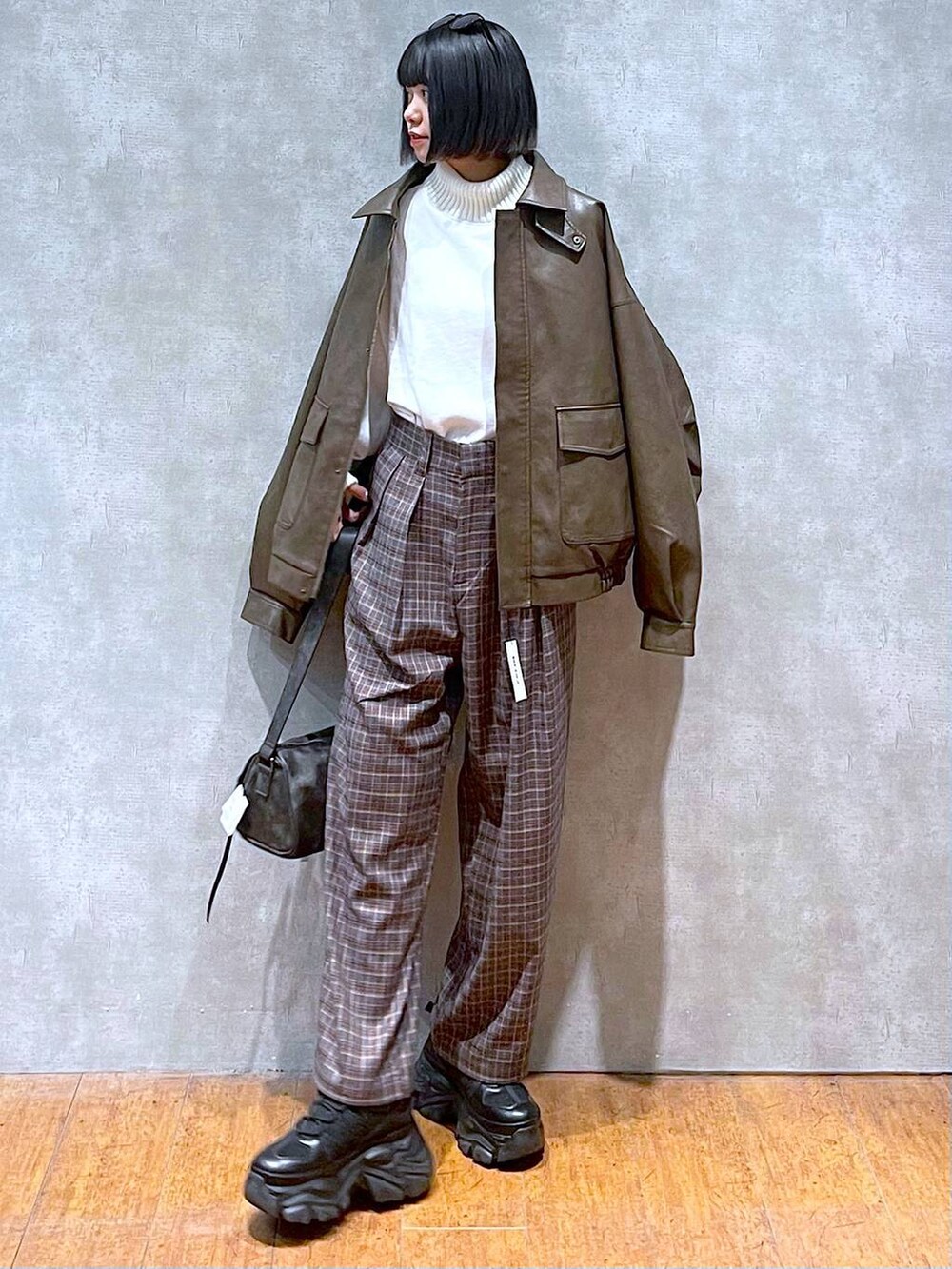 ブラック系のスニーカー、ブラック系のショルダーバッグ、ブラウン系のブルゾンを着用したレディースの秋コーディネートの9枚目の写真