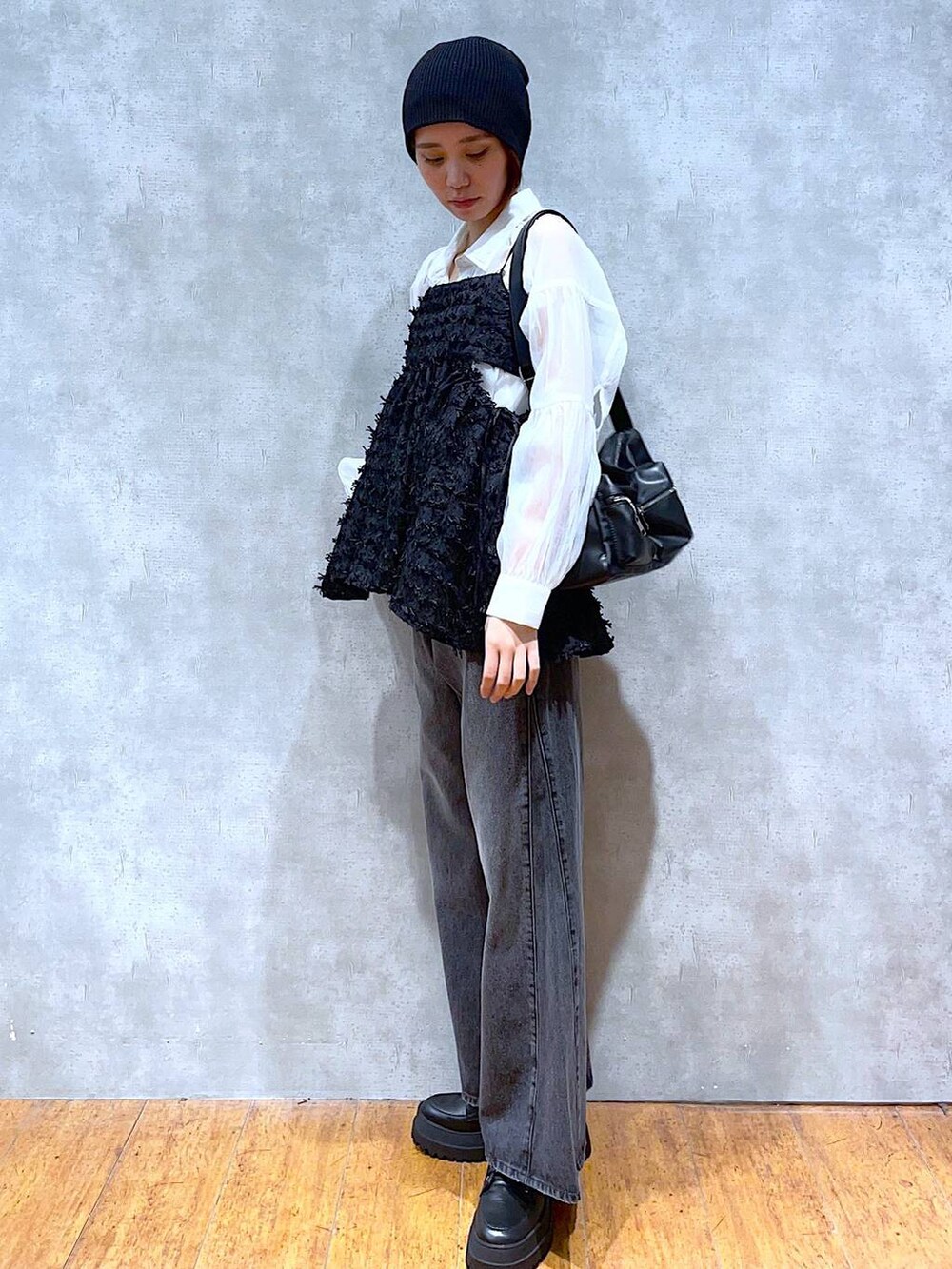 ブラック系のブーツ、ブラック系のデニムパンツ、ホワイト系のシャツ/ブラウスを着用したレディースの夏コーディネートの2枚目の写真