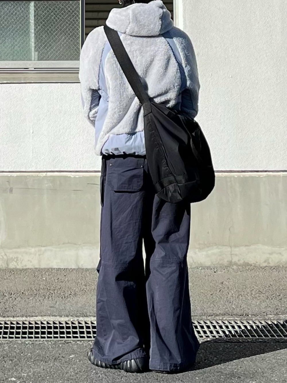 グレー系のその他アウター、ブルー系のカーゴパンツ、ブラック系のスニーカーを着用したメンズの冬コーディネートの3枚目の写真