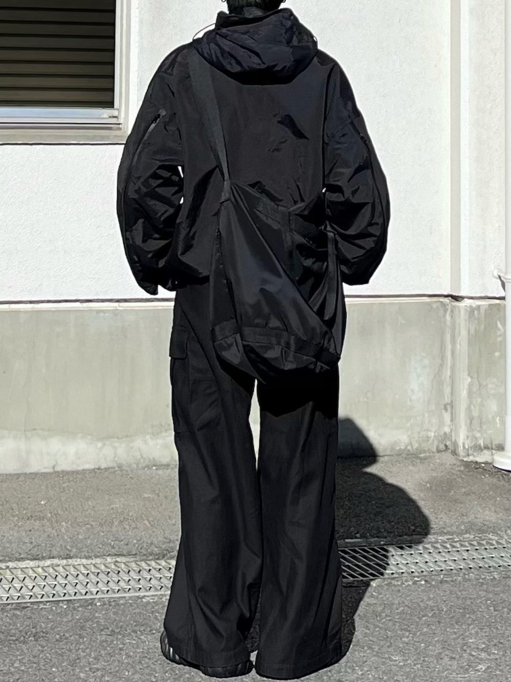 ブラック系のマウンテンパーカー、ブラック系のカーゴパンツ、ブラック系のスニーカーを着用したメンズの冬コーディネートの3枚目の写真